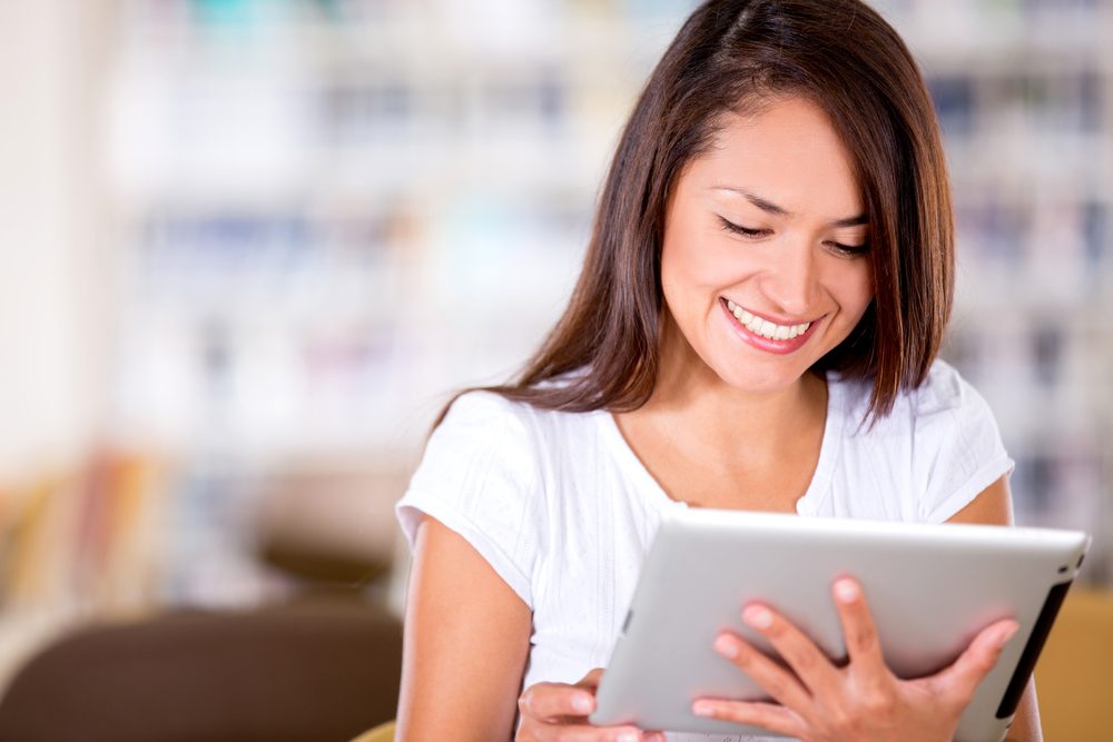 Woman,Reading,At,The,Library,On,An,E-book,Reader